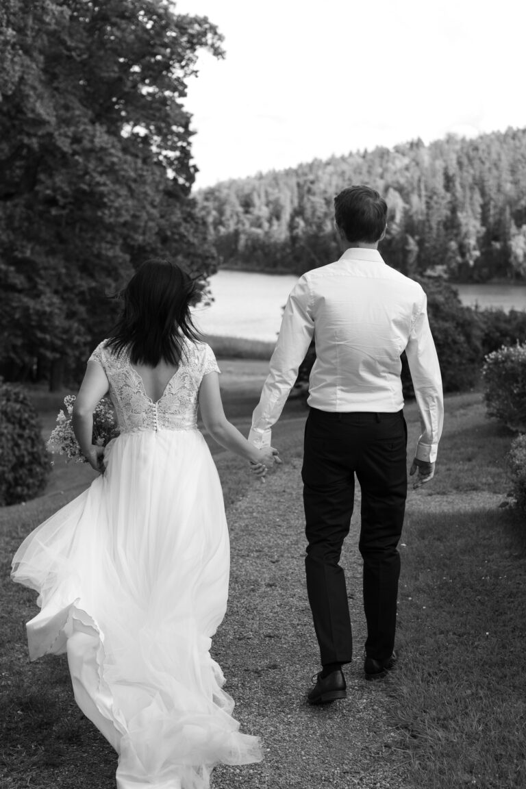 A wedding photo of a married couple holding hands takin in natural light by Photo by Tessa