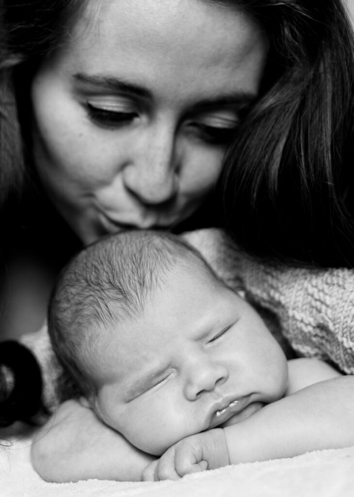 A close-up of a mother kissin her babys head captured by Photo by Tessa